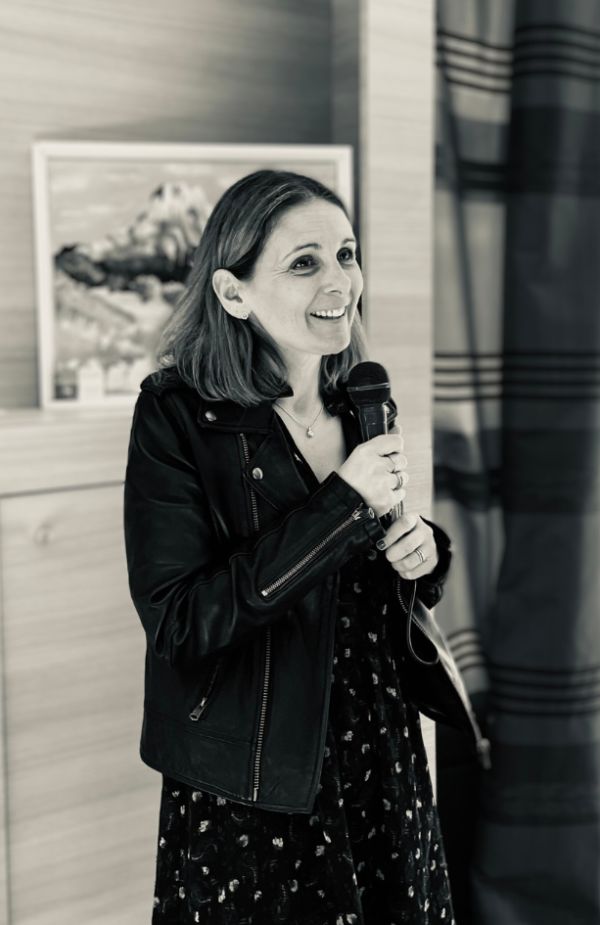 Laetitia debout tenant un micro, s'adresse à un groupe de personnes lors d'une formation.
