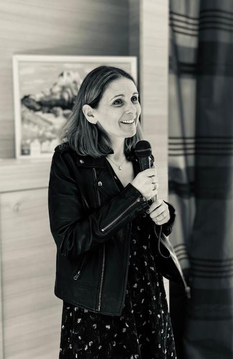 Laetitia debout tenant un micro, s'adresse à un groupe de personnes lors d'une formation.
